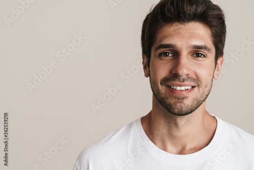 Portrait of joyful young man smiling and looking at camera