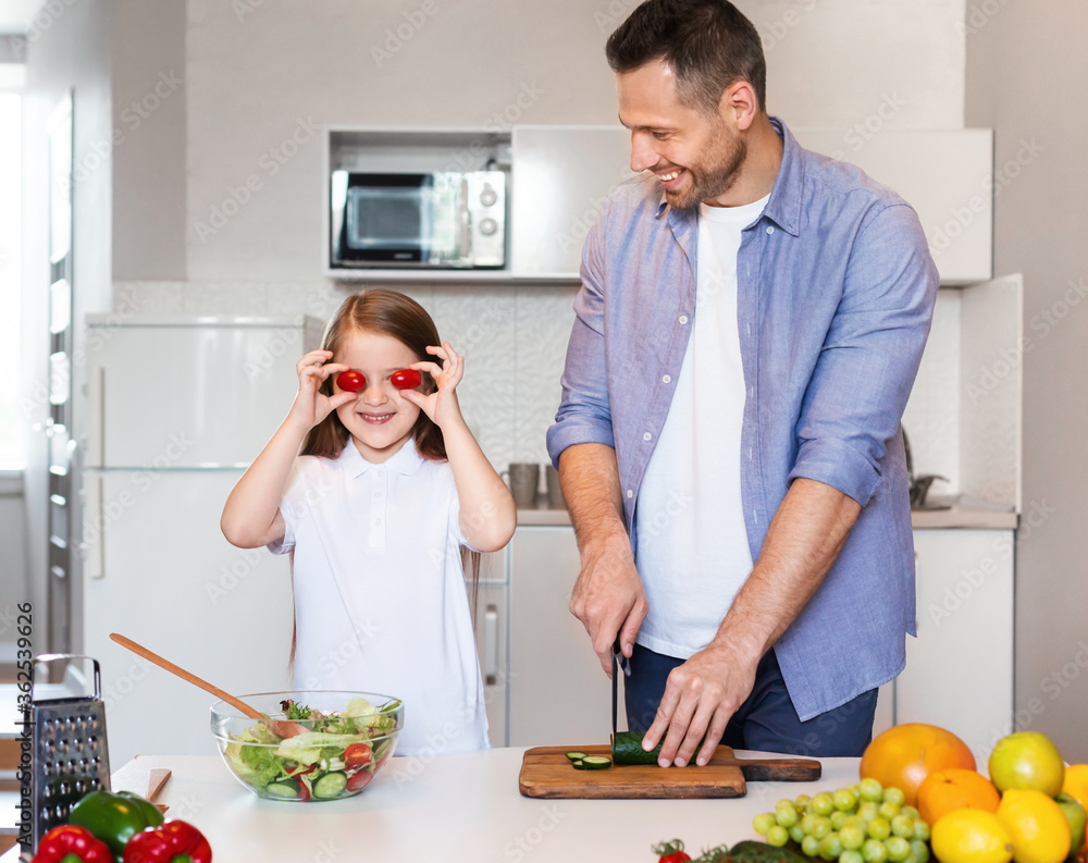Father And Daughter Cooking Having Fun With Food In Kitchen Father And Daughter Cooking Having Fun With Food In Kitchen