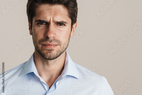 Portrait of unshaven displeased man posing and looking at camera
