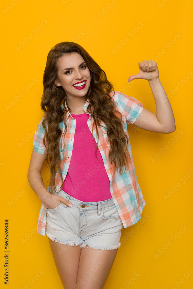 Confident Smiling Woman In Unbuttoned Lumberjack Shirt And Shorts Is Pointing At Herself Confident Smiling Woman In Unbuttoned Lumberjack Shirt And Shorts Is Pointing At Herself
