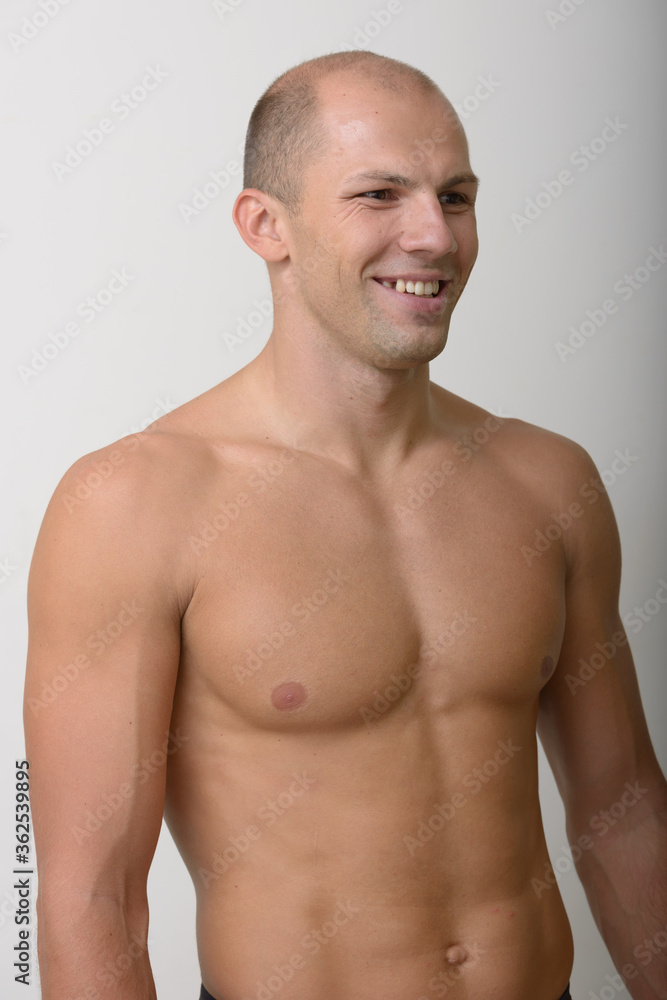 Happy young muscular bald man thinking shirtless Happy young muscular bald man thinking shirtless