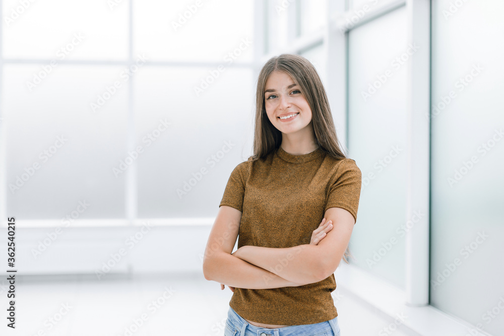 smiling young woman standing in bright office . smiling young woman standing in bright office .