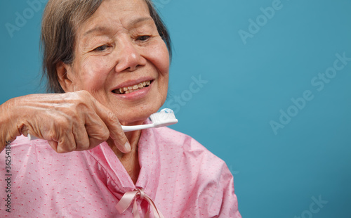 asian elderly woman using toothbrush.