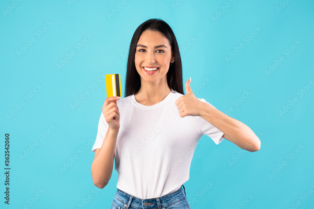 Girl holding credit card and showing thumb up Girl holding credit card and showing thumb up