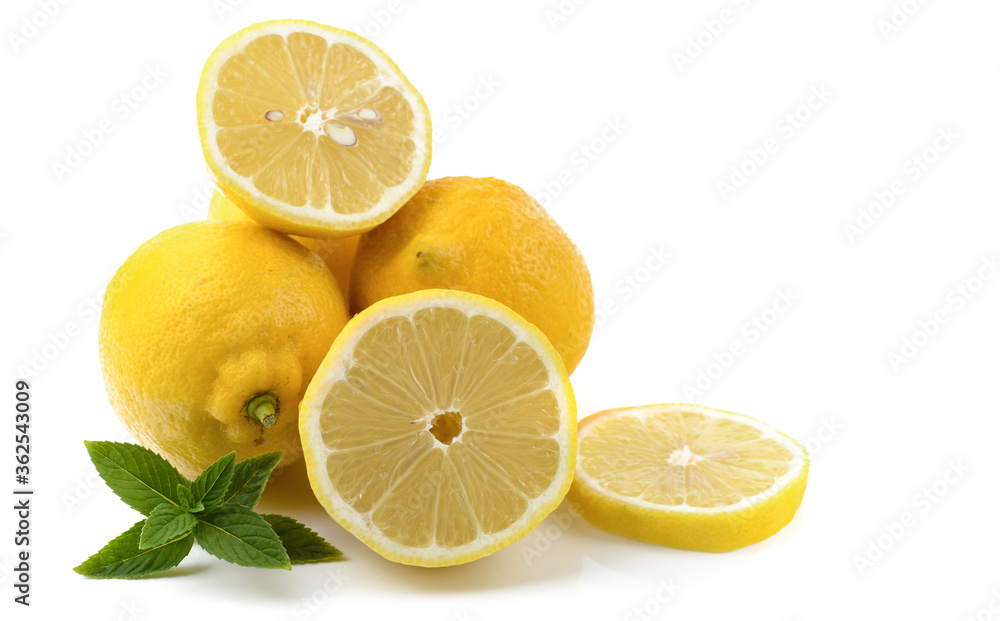 lemons whole and sliced, mint leaves, close-up on a white background, text space, horizontal view lemons whole and sliced, mint leaves, close-up on a white background, text space, horizontal view