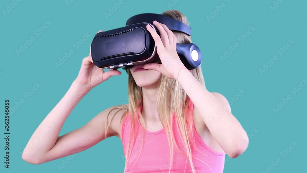 Close-up portrait of attractive long-haired girl in augmented reality glasses and moving head, enjoying 3d video, taking it off and expressing her positive emotions.People and fun concept. Close-up portrait of attractive long-haired girl in augmented reality glasses and moving head, enjoying 3d video, taking it off and expressing her positive emotions.People and fun concept.
