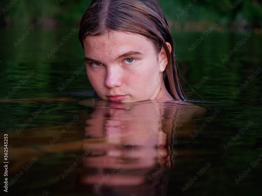 mermaid girl in the water among water lilies at sunset