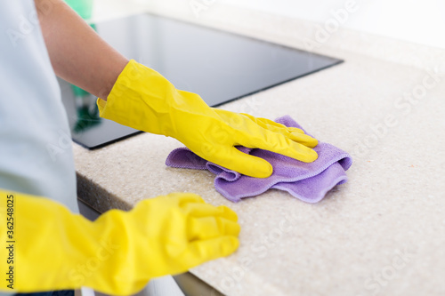 Woman's hands cleaning kitchen top