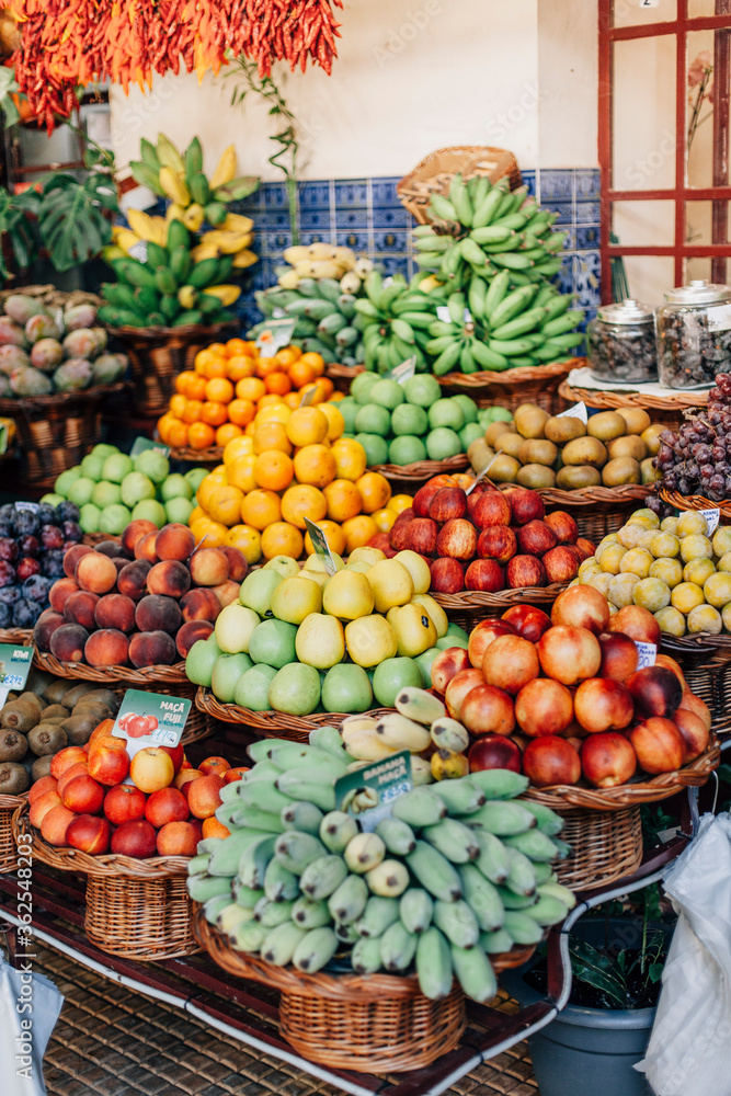 Funchal - Madeira, 20.09.2019. Fruit baskets at a farmers fair. Apples, bananas, peaches, kiwi and others. Vertical photo of a market counter.
