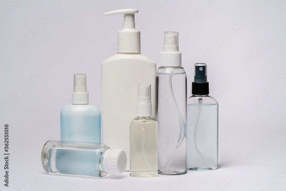 group of hand sanitizer spray or liquid soap bottles over light grey background group of hand sanitizer spray or liquid soap bottles over light grey background