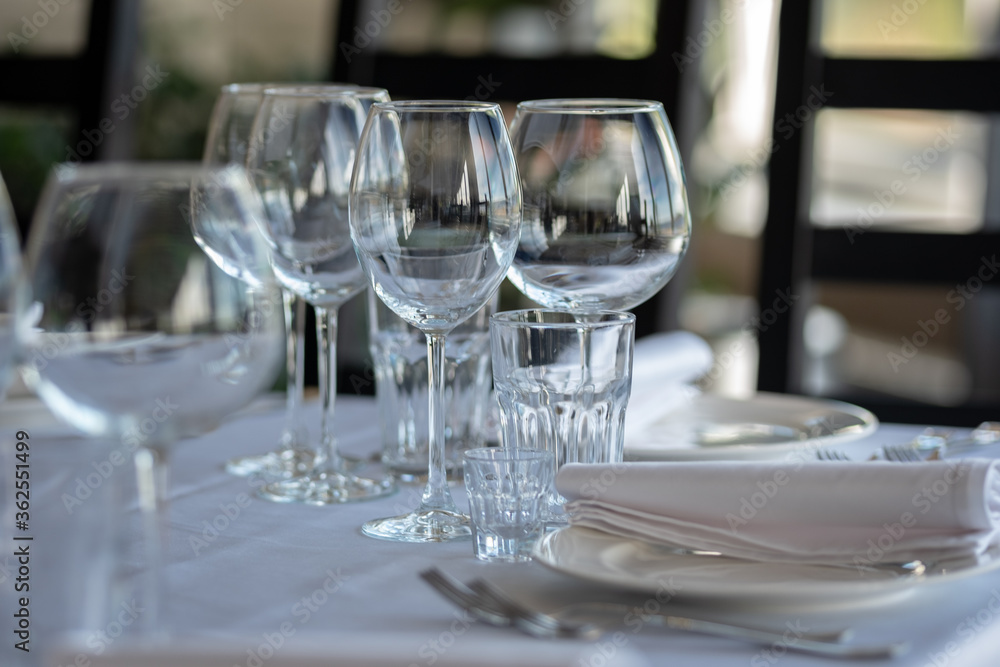 Empty glasses in restaurant background. Table set for an event party or wedding reception. Empty glasses in restaurant background. Table set for an event party or wedding reception.