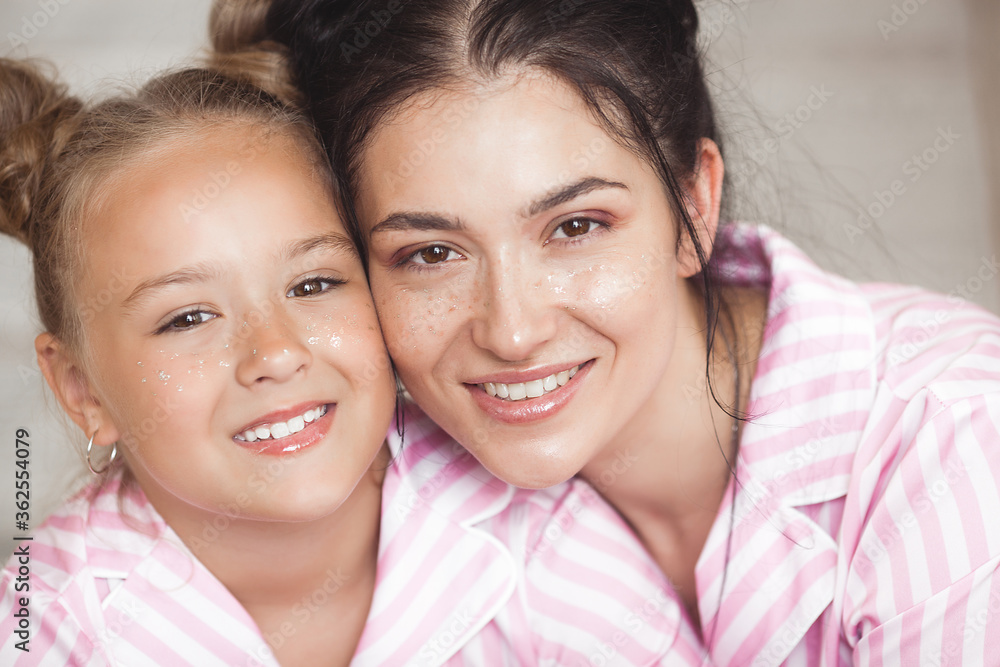 Attracive young mother and her little daughter in the bedroom. Attracive young mother and her little daughter in the bedroom.