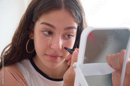 Teenager practicing makeup in her room