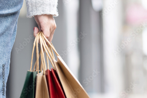Closeup of woman hand holding shopping bag colorful paper on the street happy summer with copy space