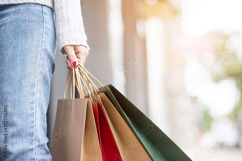 Closeup of woman hand holding shopping bag colorful paper on the street happy summer with copy space
