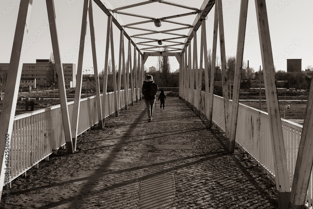 A woman and a small child on a dilapidated bridge, old rusty bridge, two people on a bridge, black and white photo A woman and a small child on a dilapidated bridge, old rusty bridge, two people on a bridge, black and white photo
