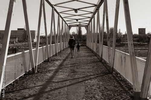 A woman and a small child on a dilapidated bridge, old rusty bridge, two people on a bridge, black and white photo