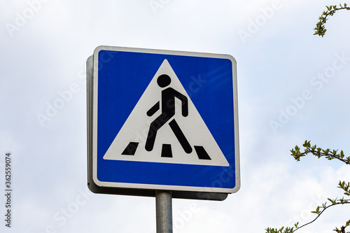 Pedestrian crossing sign on sky background.