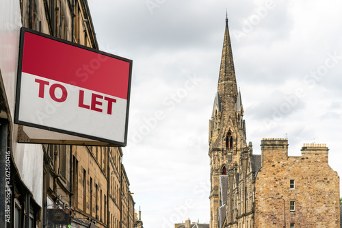 Fotografía Estate agency 'To Let' sign board with typical British buildings in the backgrou