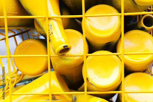 Glass bottles of yellow color in a metal container from the lattice. Recycling glassware. Attention to the environment.