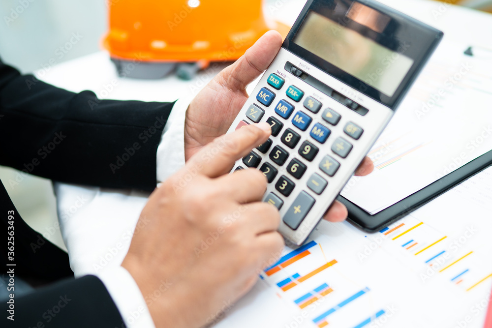 Asian accountant working and analyzing financial reports project accounting with chart graph and calculator in modern office,finance and business concept. Asian accountant working and analyzing financial reports project accounting with chart graph and calculator in modern office,finance and business concept.