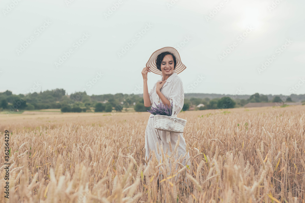 portrait of a model girl in a wheat field, a girl walks through a wheat field and holds a basket with lavender in her hands portrait of a model girl in a wheat field, a girl walks through a wheat field and holds a basket with lavender in her hands