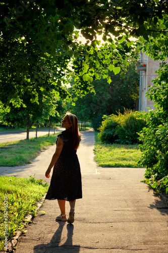 A woman walks in the summer on the streets of the city