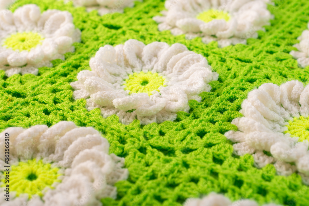 Closeup pattern of knitted woolen threads forming flowers with petals
