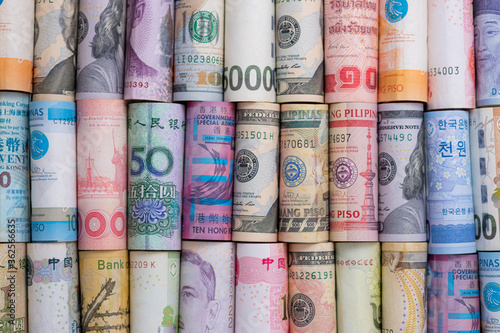Closeup rolled of variety banknote and multi currency around the world. Exchange rate and Forex investment concept.-Image. photo