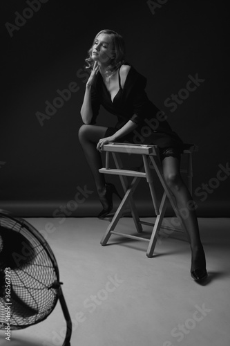 High Fashion Sexy Woman. Erotic Portrait Of Beautiful Model On Chair. Seductive Look In Stockings And Jacket.