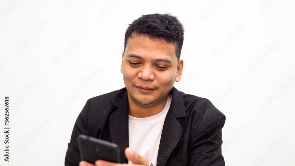 A portrait of young business Asian man smiling while looking at the smartphone screen with isolated on white background. Business and entrepreneur concept. A portrait of young business Asian man smiling while looking at the smartphone screen with isolated on white background. Business and entrepreneur concept.