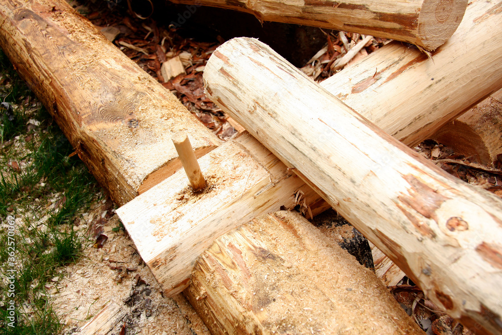 The construction of a wooden house. Assembly instructions for wooden structures. Stacking logs. Close-up.
