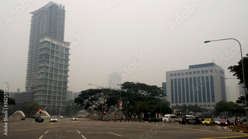  view of road junction with traffic light ,car and background of big building and trees at Singapore