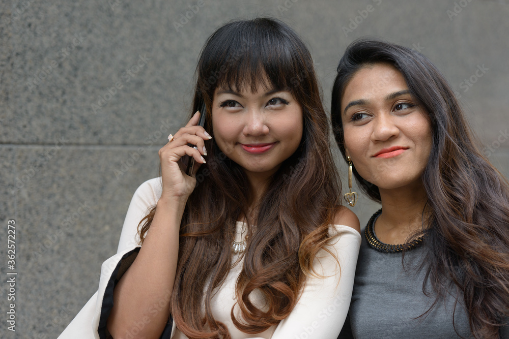 Portrait of two young Asian businesswomen together in the city Portrait of two young Asian businesswomen together in the city