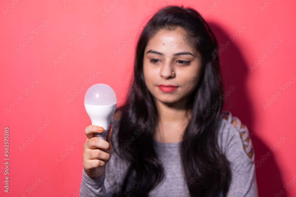 Pretty young woman holding a luminous led light bulb. Green energy , saving of energy with led bulb. Pretty young woman holding a luminous led light bulb. Green energy , saving of energy with led bulb.