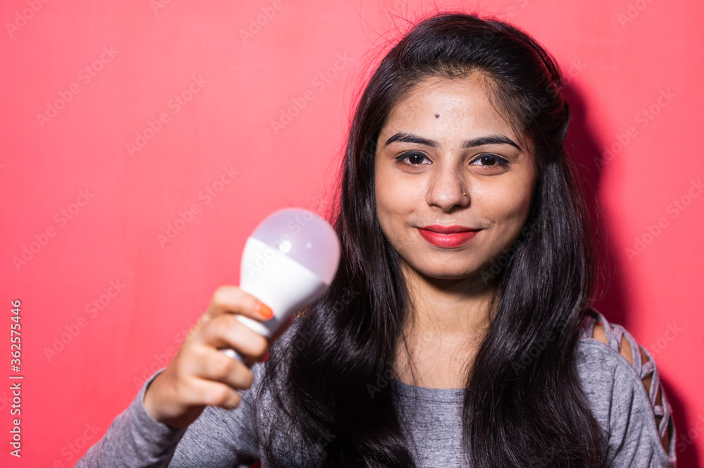 Pretty young woman holding a luminous led light bulb. Green energy , saving of energy with led bulb. Pretty young woman holding a luminous led light bulb. Green energy , saving of energy with led bulb.