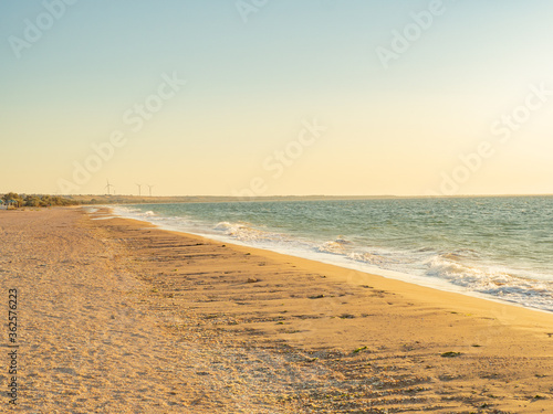 deserted beach at sunset with wind generators