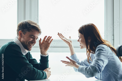 A man and a woman are sitting at a table communicating