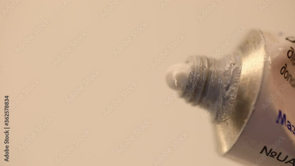 white ointment comes out of a metal tube, close-up white ointment comes out of a metal tube, close-up