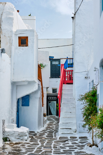 Fototapeta Naklejka Na Ścianę i Meble -  Picturesque scenic narrow Greek streets with traditional whitewashed houses with blue doors windows of Mykonos town in famous tourist attraction Mykonos island, Greece