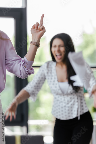 Wallpaper Mural selective focus of businesswoman showing middle finger to angry coworker Torontodigital.ca