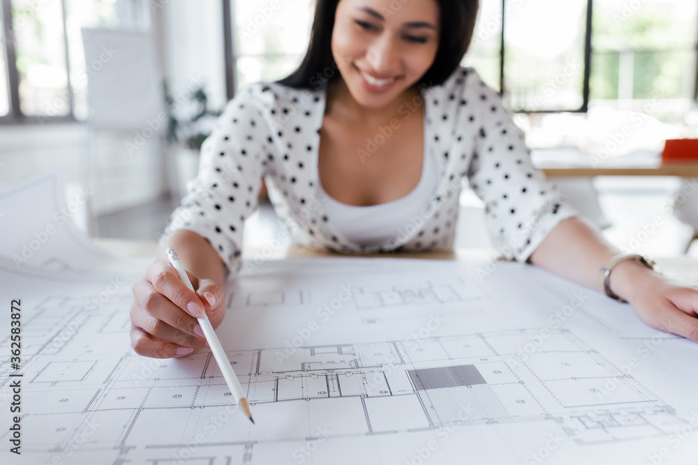 selective focus of happy businesswoman drawing blueprints in office selective focus of happy businesswoman drawing blueprints in office