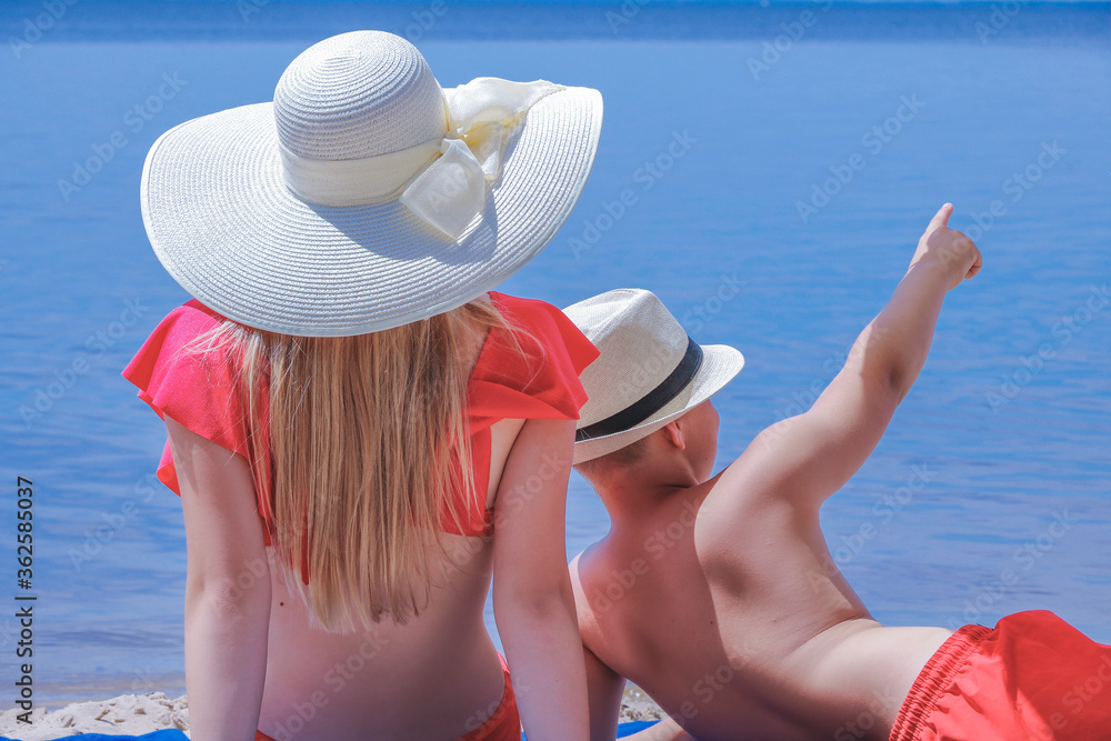 children on the beach relax in the summer on vacation looking into the distance