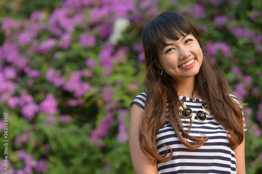 Happy young beautiful Asian woman smiling at the park Happy young beautiful Asian woman smiling at the park