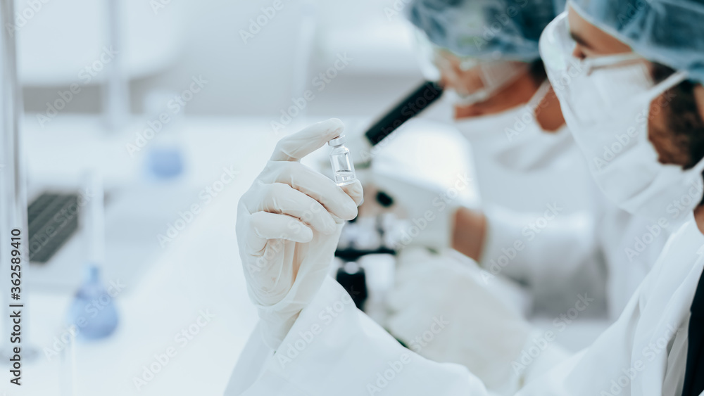 close up. ampoule with a new vaccine in the hands of a scientist. close up. ampoule with a new vaccine in the hands of a scientist.