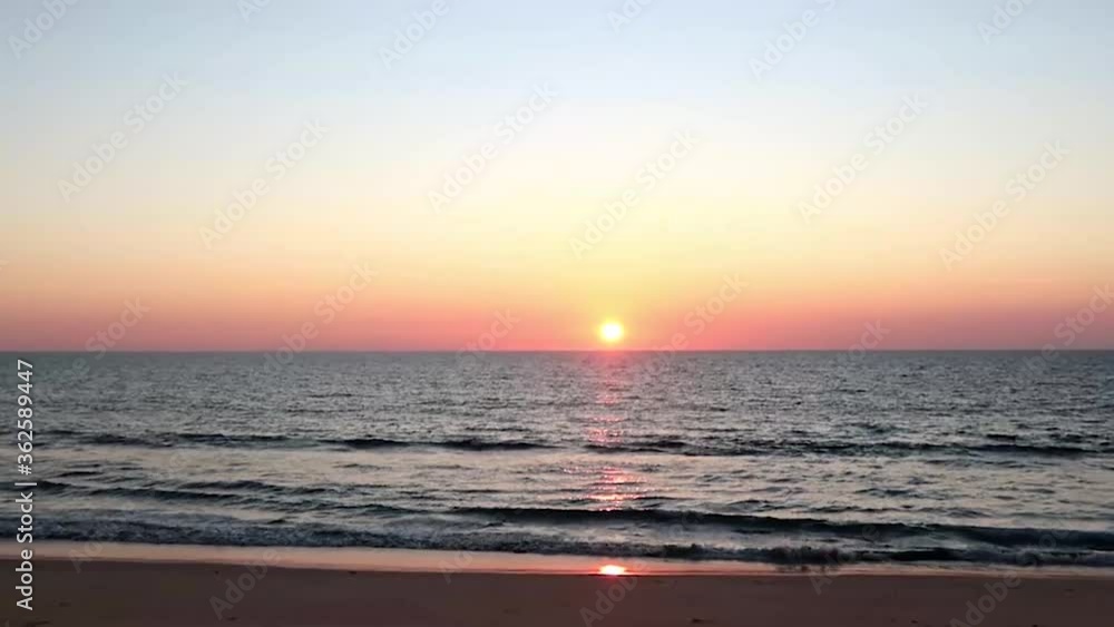 Travel & nature background of Amazing gold pink & yellow sunset sky shined on sunny clear blue horizon over calm ocean waves & sea water surface reflection reached tropical summer beach, Slow Motion Travel & nature background of Amazing gold pink & yellow sunset sky shined on sunny clear blue horizon over calm ocean waves & sea water surface reflection reached tropical summer beach, Slow Motion