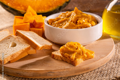 Pumpkin puree or hummus on a rustic wooden table. Selective focus