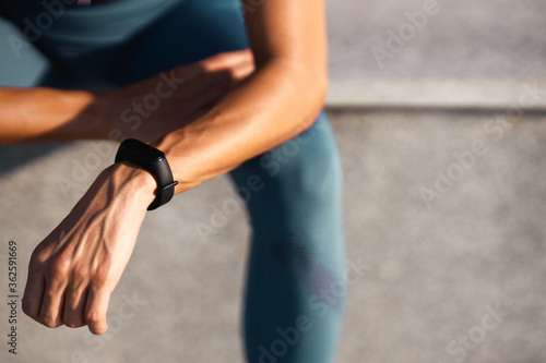 Hands of young woman with sports watch