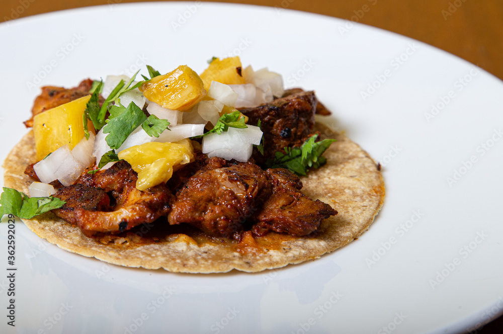 taco al pastor, mexican food isolated on a white plate taco al pastor, mexican food isolated on a white plate