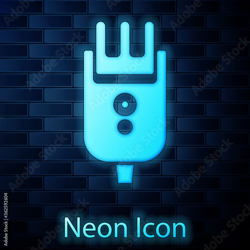 Glowing neon Electrical hair clipper or shaver icon isolated on brick wall background. Barbershop symbol. Vector Illustration.